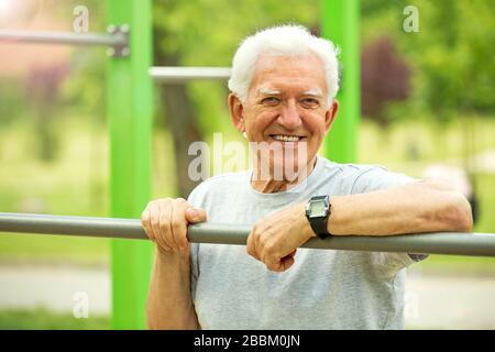 Senior Man Exercising In Park Stock Photo