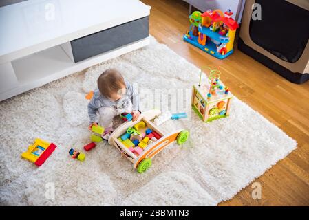 Portrait of one year old baby girl indoors in bright room Stock Photo