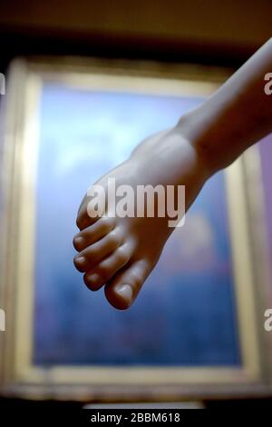 Classical foot carving framed by an oil pain ting in an art gallery. Stock Photo