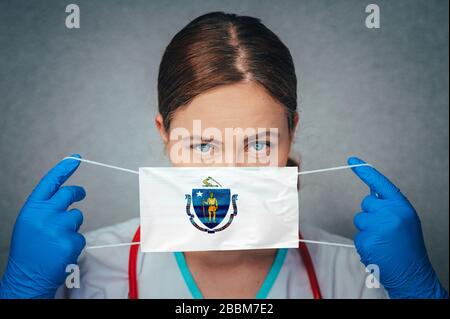 Coronavirus in U.S. State Massachusetts, Female Doctor Portrait, protect Face surgical medical mask with Massachusetts Flag. Illness, Virus Covid-19 i Stock Photo