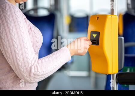 Young woman validates ticket in a public transport during ...