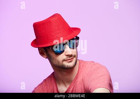 Studio shot of handsome bearded man wearing red fedora hat. Stock Photo