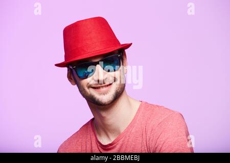 Studio shot of handsome bearded man wearing red fedora hat. Stock Photo