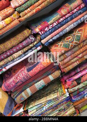 Fabrics. Bales of colourful ethnic fabrics. Abstract, full frame. Moroccan cloth, bedspreads, throws. Granada, Andalusia, Spain. Stock Photo