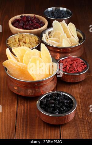 Slices of candied ginger root, pieces of dried mango fruits, dried blueberries and goji berries, dried cranberries, golden and blue raisins in small b Stock Photo