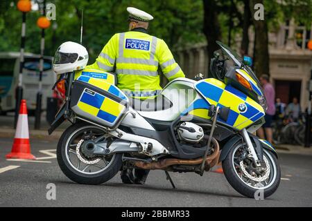 Police motorcycle officer at a road block on road leading to Parliament Square, London, to stop & divert traffic from an oncoming protest rally. Stock Photo
