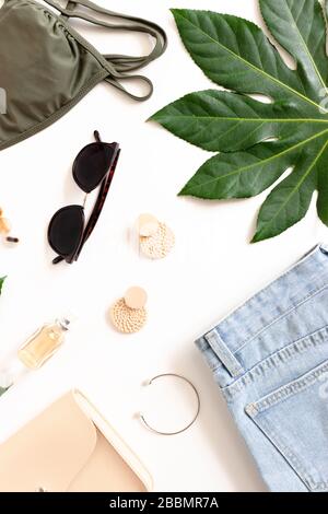 Summer composition with green leaves, handbag, women's clothes and accessories on a white background. Stock Photo