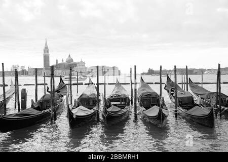 Gondolas in the front and the Saint George Greater church at the background in Venice, northern Italy. Stock Photo