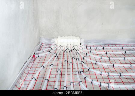 White pipes of underfloor heating systems, distributed in an individual family house on insulating foil. Stock Photo