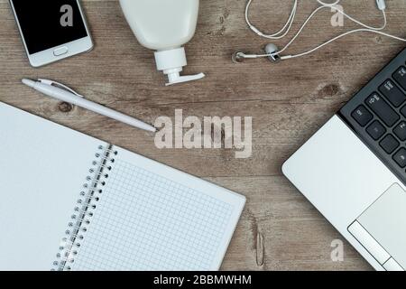 hygiene in the office. Top view close up of office desk, desktop with laptop, phone and medical face mask.  Stock Photo
