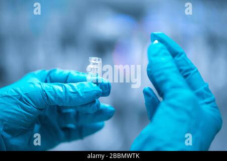 Close up of hand pharmacist with test tube with vaccine against virus, pharmacy concept Stock Photo