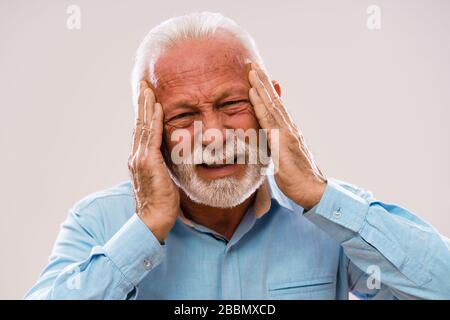 Portrait of senior man who is having headache. Stock Photo