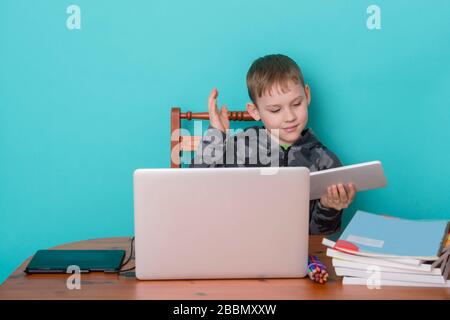 School kid using laptop while doing schoolwork at home. Homeschooling. School from home. Stock Photo