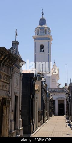 Basilica of Our Lady of the Pillar visible over the tombs in La Recoleta cemetery in Buenos Aires, Argentina Stock Photo