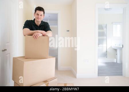Portrait Of Removal Man Carrying Boxes Into New Home On Moving Day Stock Photo