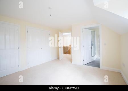 Interior View Of Beautiful Bedroom With Fitted Wardrobes And En Suite Bathroom In New Family House Stock Photo