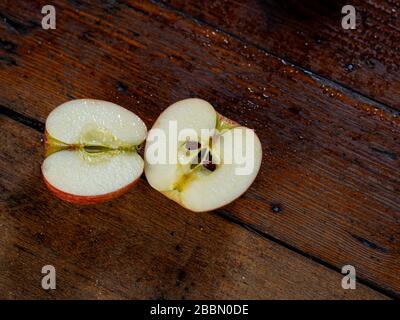 Top view of red apple cut in half on table. Stock Photo