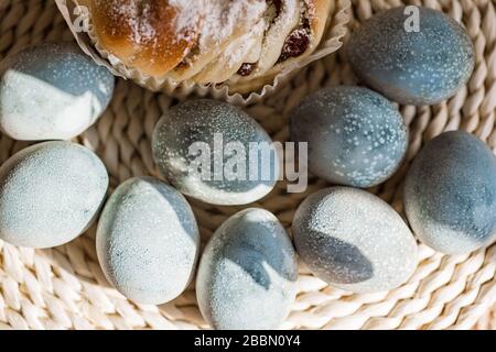 Easter cake and colored pastel eggs on the rattan napkin background. Beautiful light blue eggs. Easter background. Happy Easter concept. Thrush eggs. Stock Photo