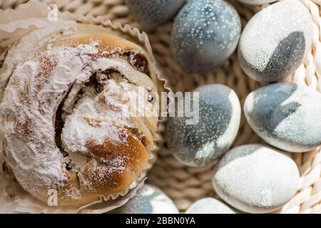 Easter cake and colored pastel eggs on the rattan napkin background. Beautiful light blue eggs. Easter background. Happy Easter concept. Thrush eggs. Stock Photo