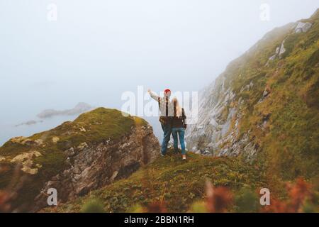 Hugging couple travel outdoor vacations romantic lifestyle family relationship man and woman together enjoying foggy sea view in Norway Stock Photo