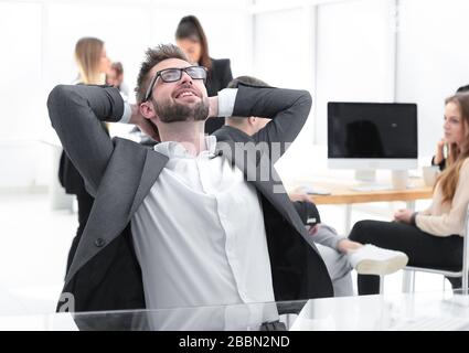 brooding young businessman sitting at an office Desk Stock Photo