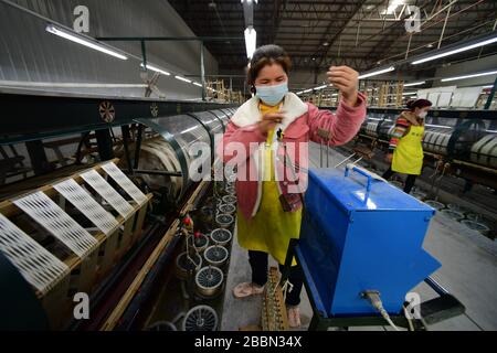 (200401) -- RONGJIANG, April 1, 2020 (Xinhua) -- People work in a silk enterprise in Rongjiang County, southwest China's Guizhou Province, April 1, 2020. As one of the nine poverty-stricken Counties in Guizhou Province that have not been lifted out of poverty, Rongjiang County has focused on promoting the resumption of production of enterprises in the County and the export of labor services since February. Up to now, more than 140,000 people have been employed among the existing 190,000 laborers in Rongjiang County. (Xinhua/Yang Ying) Stock Photo