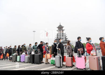 (200401) -- RONGJIANG, April 1, 2020 (Xinhua) -- Migrant workers line up before Rongjiang Railway Station in Rongjiang County, southwest China's Guizhou Province, April 1, 2020. As one of the nine poverty-stricken Counties in Guizhou Province that have not been lifted out of poverty, Rongjiang County has focused on promoting the resumption of production of enterprises in the County and the export of labor services since February. Up to now, more than 140,000 people have been employed among the existing 190,000 laborers in Rongjiang County. (Xinhua/Wang Bingzhen) Stock Photo