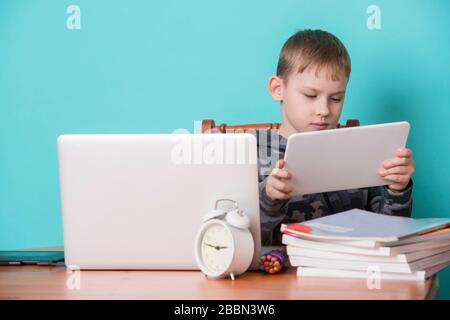 School kid using laptop while doing schoolwork at home. Homeschooling. School from home. Stock Photo
