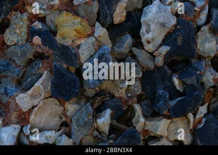 Multi colored stones texture on wall for background. Colorful stones background, different shapes and colors. Stock Photo