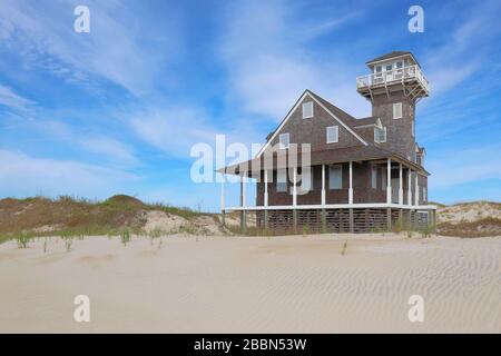 The historic Pea Island Life Saving Station with sand dunes under ...