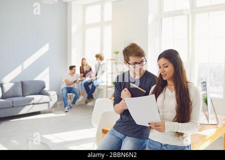 Teamwork. Students prepare a job analyze discuss business strategies at a table in the office. Stock Photo