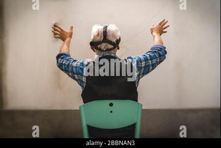 mature man is looking through the viewer of virtual reality during tough quarantine at the time of coronavirus Stock Photo