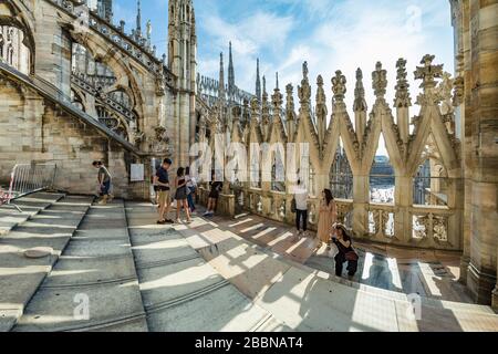 Milan, Italy - Aug 1, 2019: Numerous tourists walk on the observation deck on the roof of Milan Cathedral - Duomo di Milano, Lombardy, Italy.