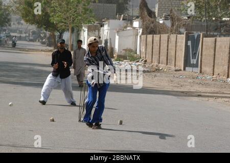 Boys playing cricket on the street in Karachi Stock Photo