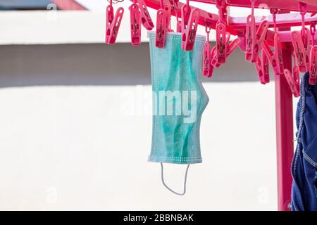 The mask is dried in the sun with a clothespin for further use. Stock Photo