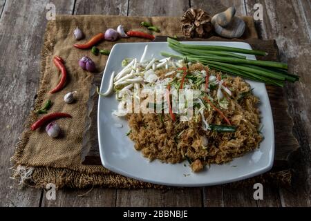 Asian eating food, Mee Grob is an sweet and sour crispy noodles, made from Thai rice noodle with sweet and sour sauce on white plate, Sweet & Sour Cri Stock Photo