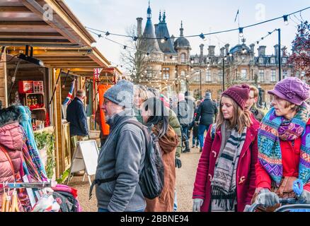 Shoppers in woolly hats and scarves, looking around the stalls at the Christmas Market (2017), Waddesdon Manor, Buckinghamshire, England. Stock Photo