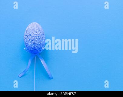 Easter minimalistic banner in blue color. Flat lay with copy space. Single egg at the left. Stock photo. Stock Photo