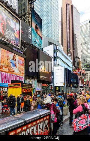 People walking around in a busy Times Square in New York Stock Photo