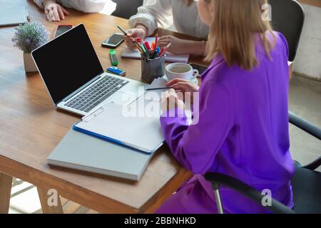 Details. Young caucasian business woman in modern office with team. Meeting, tasks giving. Women in front-office working. Concept of finance, business, girl power, inclusion, diversity, feminism. Stock Photo