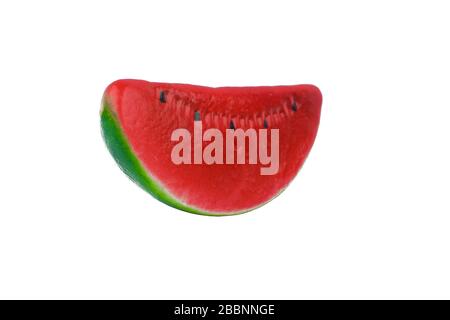 Miniature figurine of a fake red ripe watermelon isolated on an empty white background Stock Photo