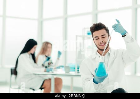close up. man scientist holding a flask of blue liquid Stock Photo
