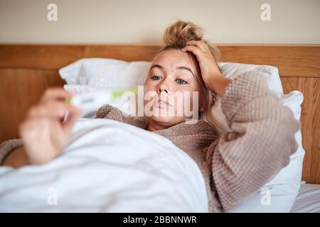 A Single, blonde haired, Caucasian female ill in bed with a seasonal virus