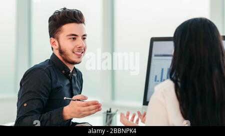 rear view. two employees discuss work issues sitting at the off Stock Photo