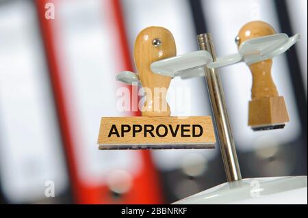 approved printed on rubber stamp in hand Stock Photo