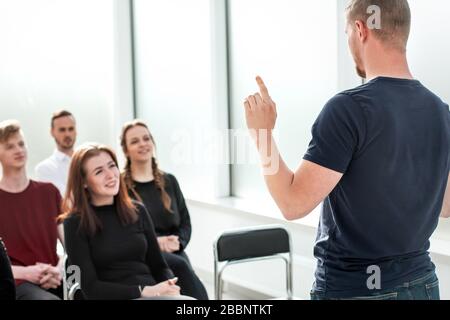 speaker makes a report for a group of diverse young people. Stock Photo