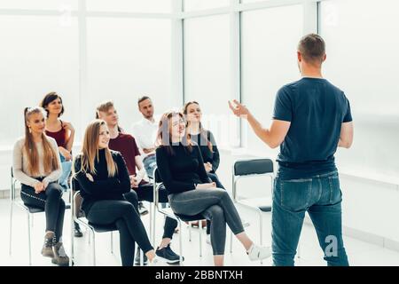 speaker makes a report for a group of diverse young people. Stock Photo