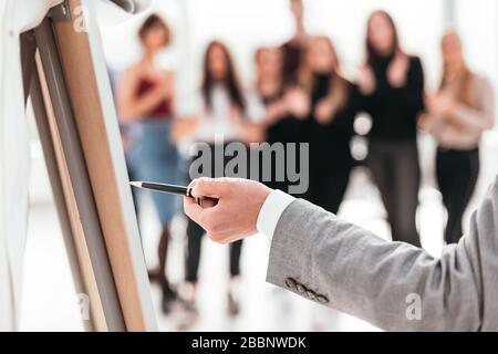 rear view . business man pointing with pen on a flipchart. Stock Photo