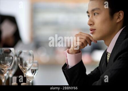 Young adult businessman sitting at a table in a restaurant. Stock Photo