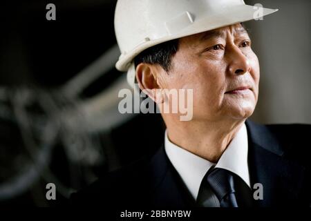 Mature adult businessman wearing a hard hat. Stock Photo
